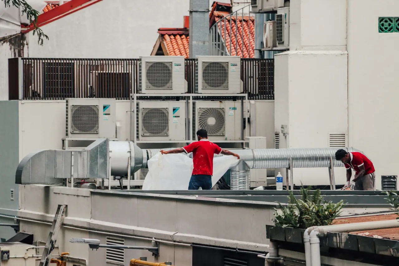 Technicians servicing a commercial rooftop HVAC unit