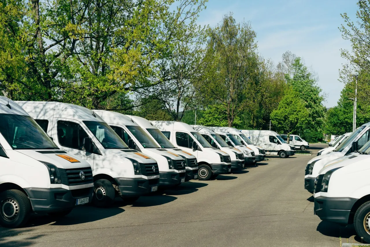 Fleet of white commercial service vans parked in neat rows